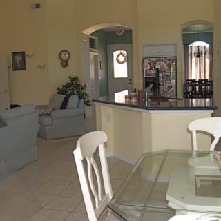 An open-plan living area with a dining table, seating, and a view of the kitchen.