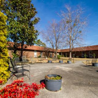 A peaceful courtyard featuring planters, benches, and a clear blue sky.
