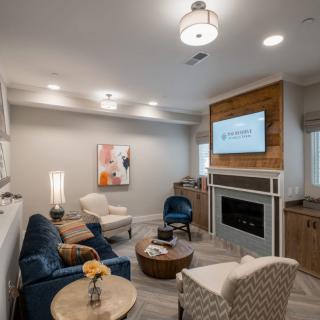 A modern, cozy living room with comfortable seating and a fireplace.