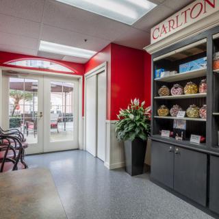 A bright store interior with red walls, displaying products on shelves and a seating area near the entrance.