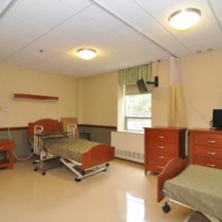 A hospital room with two beds and medical equipment.
