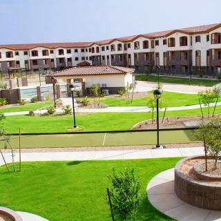 A modern residential complex surrounded by well-maintained green spaces and pathways.