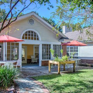 A beautiful backyard view with patio, garden, and sunshades.