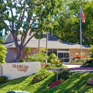 A residential building with a well-maintained garden and an American flag flying nearby.