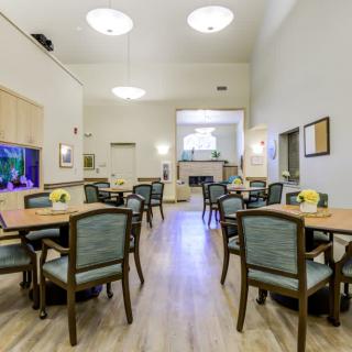 A bright and modern dining area with multiple tables and chairs, creating a welcoming community space.