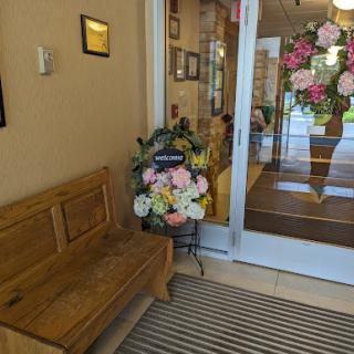 A cozy entrance featuring a wooden bench and a beautiful floral arrangement.