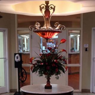 A beautifully decorated lobby with a striking chandelier and floral arrangement.