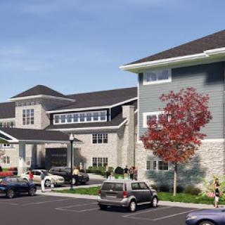 A modern residential building featuring attractive architecture and a well-maintained parking area.