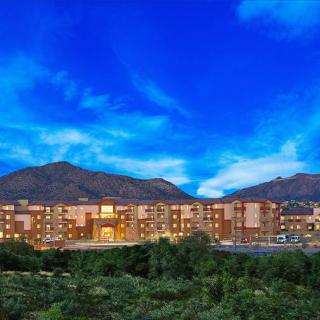 A hotel building set against a backdrop of mountains during the evening.