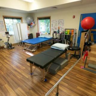 A physical therapy room equipped with various rehabilitation and exercise equipment.