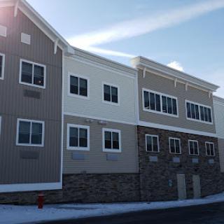 A modern residential building with a two-tone facade, situated in a snowy environment.