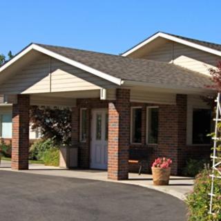 An entrance to a residential building with a brick facade and a clear sky in the background.