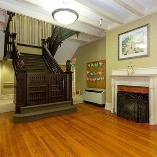 A classic interior featuring a wooden staircase and fireplace with elegant decor.