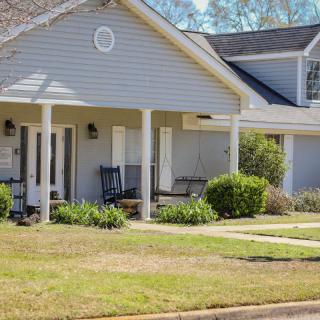 A suburban house with a welcoming porch and a well-maintained garden.