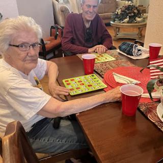 Two seniors enjoying a friendly game of bingo together.