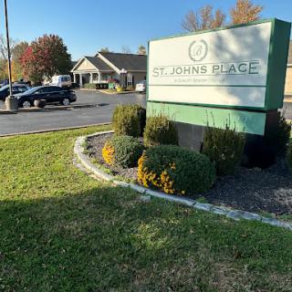 A welcoming entrance to St. John's Place, showcasing a well-maintained landscape and clear signage.