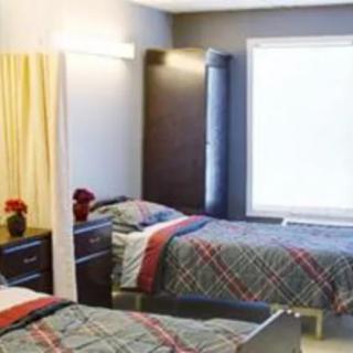 A cozy bedroom with twin beds and a large window.