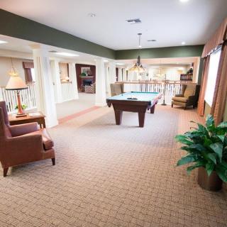 A spacious game room with a pool table and comfortable seating.
