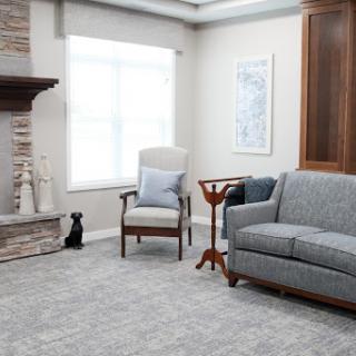 A modern and cozy living room featuring a comfortable gray sofa, an armchair, and a stylish fireplace.