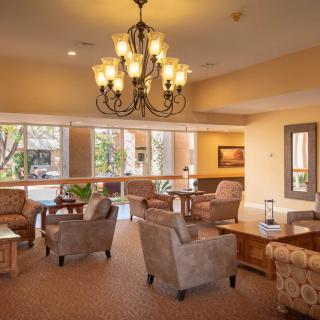 A cozy lobby with comfortable seating, elegant chandelier, and large windows.