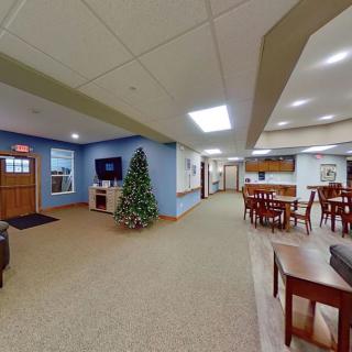 A spacious living area with a Christmas tree, TV, and various seating options.