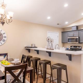 A modern kitchen with a dining area featuring bar stools and stylish decor.