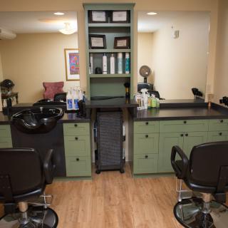 Cozy hair salon interior with styling chairs, sinks, and shelves stocked with hair products.