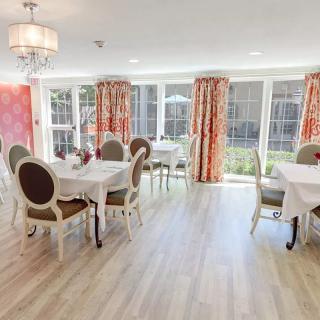 Elegant dining area with large windows and colorful curtains.