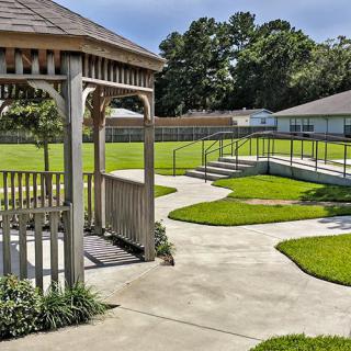 A peaceful backyard with a gazebo, winding pathways, and well-maintained lawns.