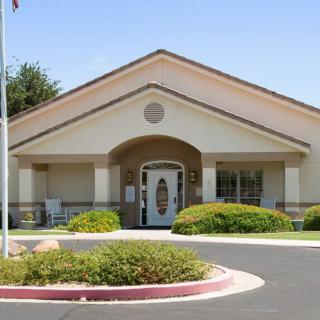 A front view of a building with well-maintained landscaping and an entrance flanked by columns.
