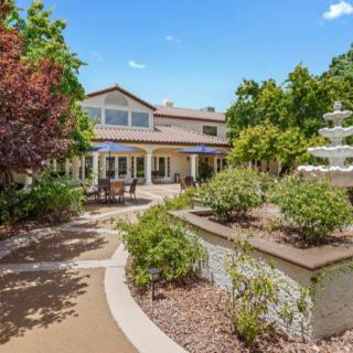 A beautiful house with a well-maintained garden and a decorative fountain.