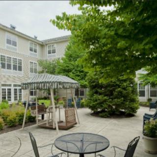 A peaceful courtyard with a gazebo and outdoor seating surrounded by trees.