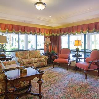 A cozy and elegantly furnished living room with large windows.