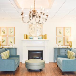 A beautifully designed living room featuring a stylish chandelier, cozy seating, and elegant decor.