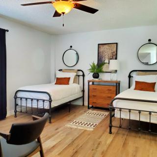 A modern bedroom with two twin beds and minimalist decor.