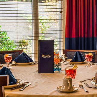 A beautifully arranged dining table with elegant settings and menus, ready for guests at a restaurant.