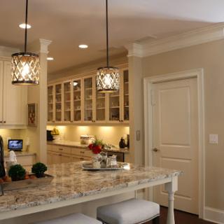 A beautifully designed modern kitchen featuring elegant lighting and a stylish bar counter.