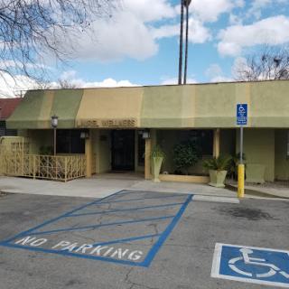 A view of a building with a designated handicap parking area and a no parking sign in front.