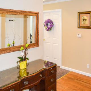 A warmly decorated entryway with a mirror, table, and decorative accents.