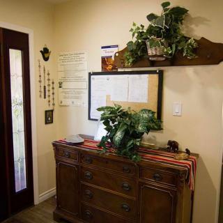 A cozy entryway with a wooden dresser adorned with plants and a mirror, creating an inviting atmosphere.