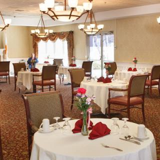A beautifully arranged dining room ready for guests, featuring elegant decor and table settings.