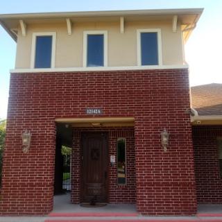 A brick building with large windows and an inviting entrance.