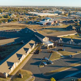 Aerial view of a commercial complex with buildings and a parking lot.
