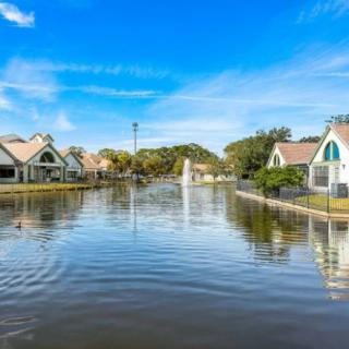 Flooded residential neighborhood under a clear blue sky.