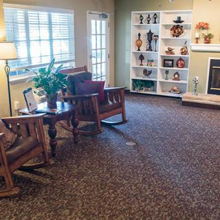 A cozy living room with comfortable seating, decorative shelves, and a fireplace.