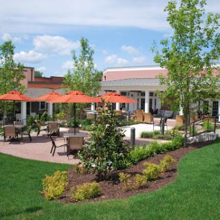 A beautifully landscaped outdoor area with seating and vibrant umbrellas, perfect for relaxation.