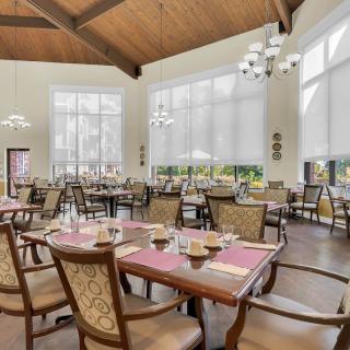 A spacious and well-lit restaurant dining area with neatly arranged tables and chairs.