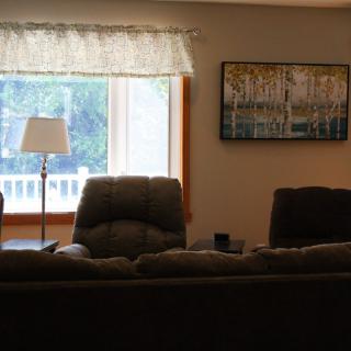A cozy living room with a sofa, lamp, and large window.
