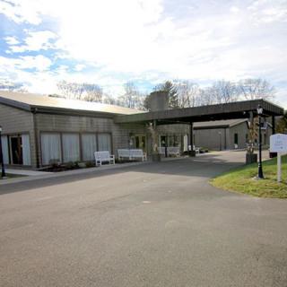 The exterior view of a funeral home under a partly cloudy sky.