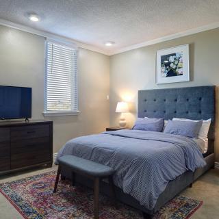 A cozy and well-decorated bedroom with a comfortable bed, modern furniture, and soft lighting.